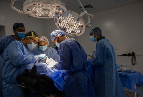 Dr Ihab Hanna in dental implant live surgery course performing operation while explaining for students dental implant process