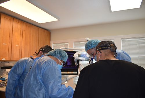 Dr Ihab Hanna in dental implant live surgery course performing operation while explaining for students dental implant process